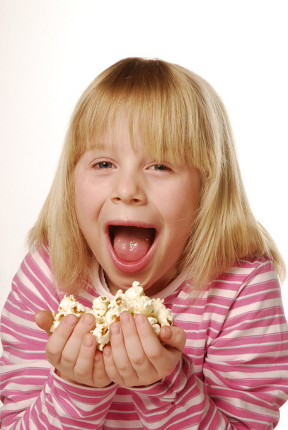 Little girl eating popcorn - Foto, imagen