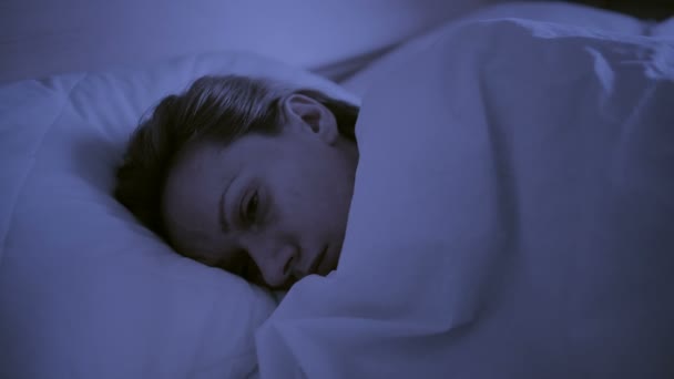 Insomnia concept. Woman in bed at night can not sleep - Footage, Video