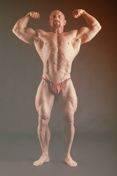 Bodybuilder showing his back and biceps muscles, personal fitnes - Fotografie, Obrázek