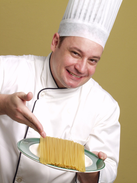 Young chef holding a pasta plate. - 写真・画像