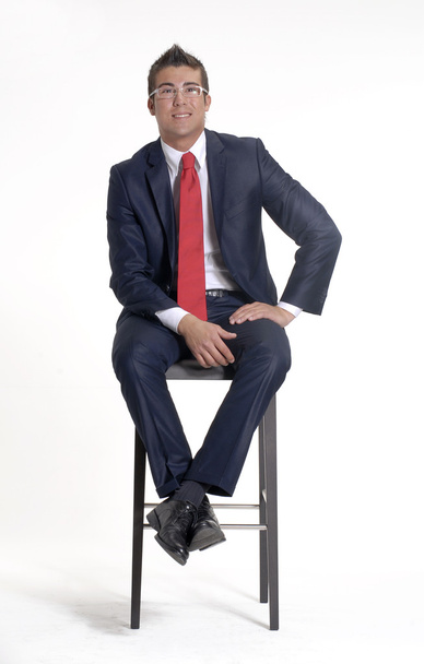 Jeune homme d'affaires assis sur une chaise sur fond blanc
. - Photo, image