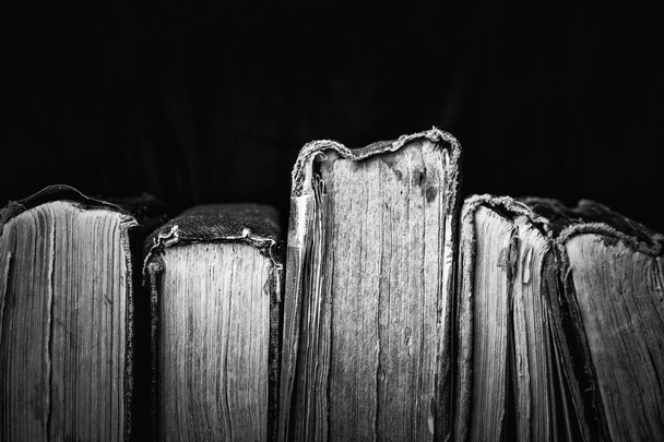 Oude vervallen verstandig boeken op donkere achtergrond. Zwart-wit fotografie - Foto, afbeelding