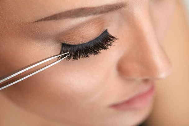 Beauty Makeup. Woman Applying Black False Eyelashes With Tweezer - Фото, зображення