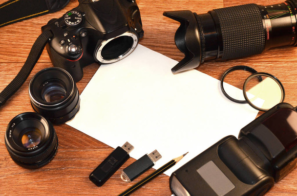 Täydellinen sarja moderni digitaalinen SLR kamera ja tyhjä paperiarkki copyspace. Peitä online valokuva tarvikkeet ja laitteet shop tai tärkein dia valokuvaus esittely
 - Valokuva, kuva