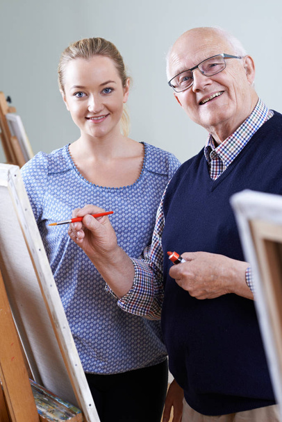 Senior Man Attending Painting Class With Teacher - Foto, imagen