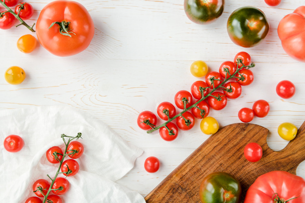 Tomatoes and cutting board - Фото, зображення