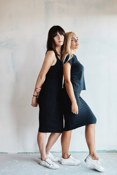 Two pretty woman in a black dress indoor - Fotó, kép