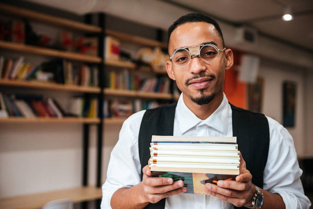 Atractivo empresario africano sosteniendo cuadernos
 - Foto, Imagen