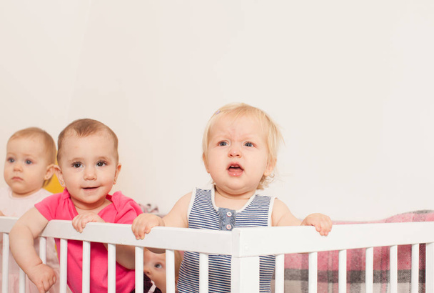 Three baby girls in the crib - Фото, изображение