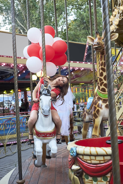 Mariée avec des ballons balades sur le carrousel
 - Photo, image
