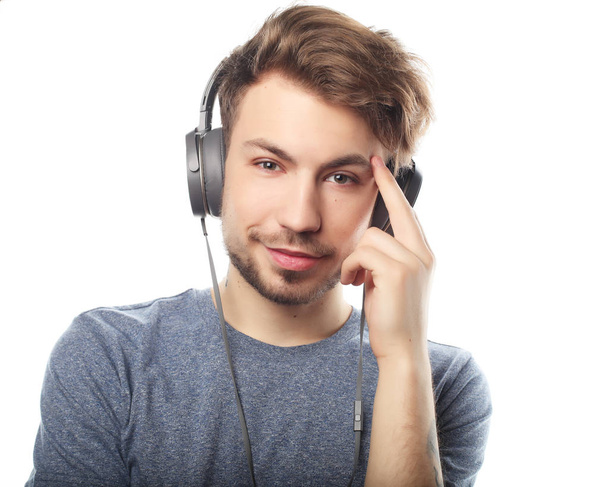 Handsome young man wearing headphones and listening to music. - Fotoğraf, Görsel