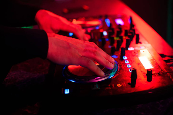 hands DJ music mixer on the party in the night club - Foto, afbeelding
