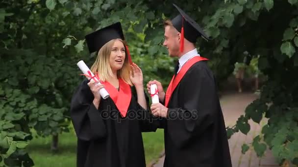 Feliz hombre y mujer graduados charlando sobre el futuro en el parque, el día de la graduación
 - Metraje, vídeo