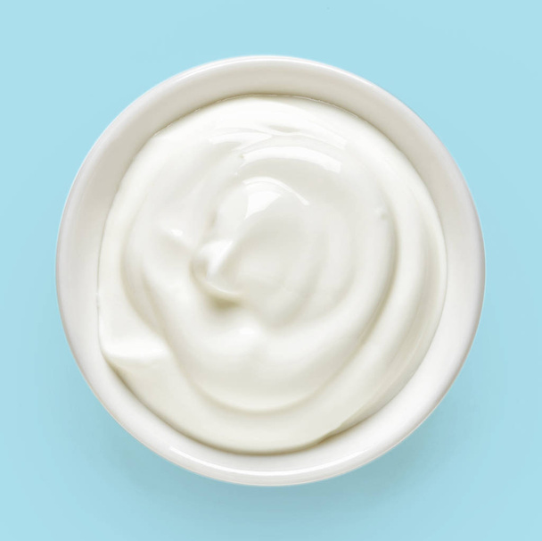 Bowl of cream on blue background, from above - Foto, imagen