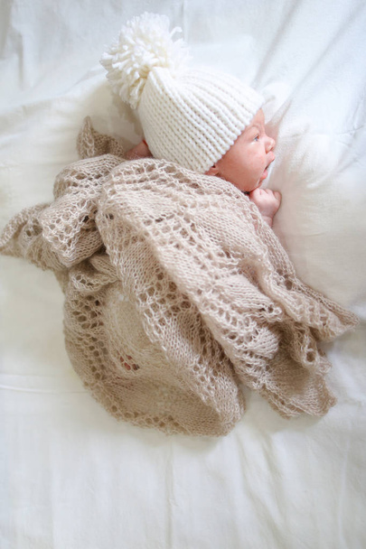 Νεογέννητο μωρό στο πλεκτό παιδί καπάκι καλύπτονται πλεκτό κουβέρτα και ly - Φωτογραφία, εικόνα