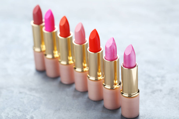 Colorful lipsticks on grey wooden table - Photo, image