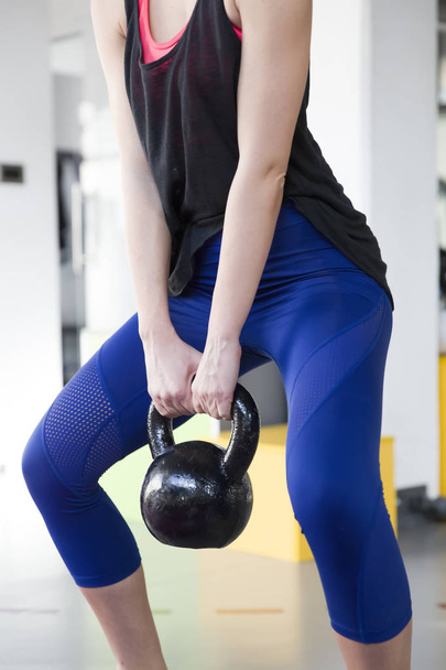Woman exercises with a kettlebell - Photo, image