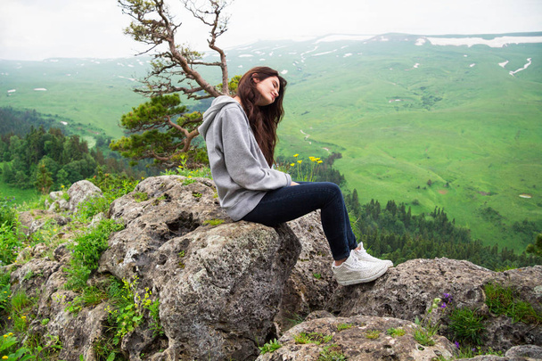 Mulher bonita sentada no topo da montanha e contemplando landsc
 - Foto, Imagem