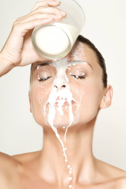 hermosa mujer verter leche en la cara
 - Foto, imagen