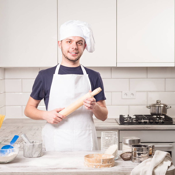 chef cook holding rolling pin with croissant on deskboard - Foto, Imagem