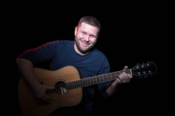 Portrait of a smiling man with guitar - Fotó, kép