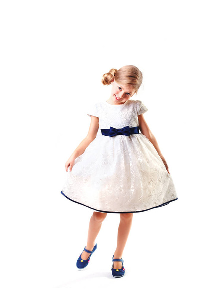 Pretty blondie six years old small girl on white background in white prom dress. - Foto, afbeelding
