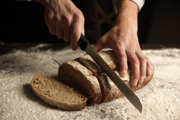 hands cutting homemade bread - 写真・画像