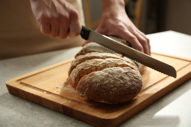 hands cutting homemade bread - Фото, зображення
