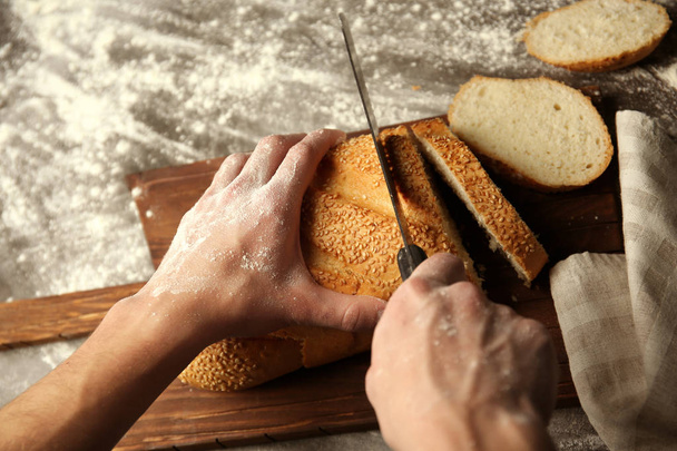 Male hands cutting  bread - 写真・画像