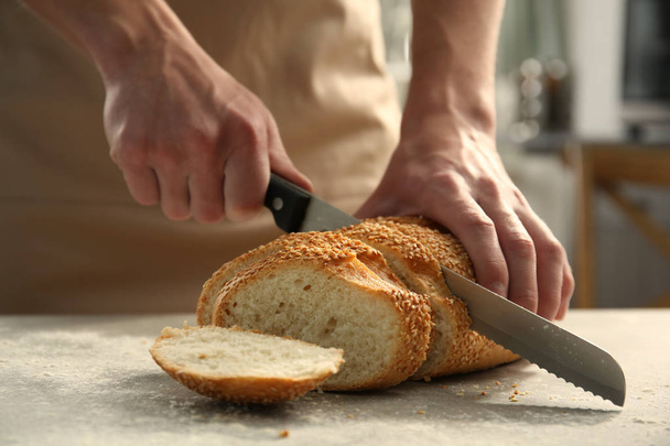 男性の手がパンを切る - 写真・画像