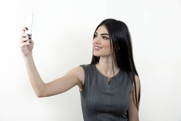 Business woman taking selfie with her smartphone. - 写真・画像