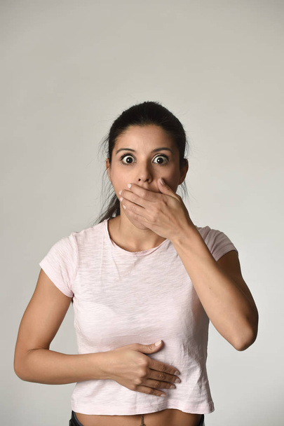 jovem bela espanhola mulher surpreso espantado com choque e surpresa cobrindo boca
 - Foto, Imagem