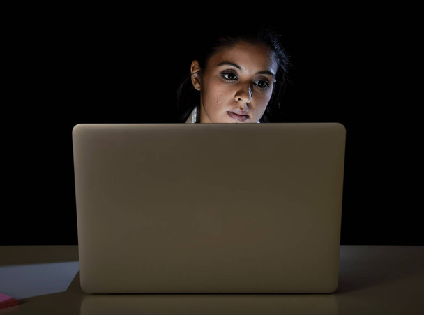 夜遅くまで探しているラップトップ コンピューターの暗闇の中で働く若いビジネス女性や学生の女の子が集中してください。 - 写真・画像