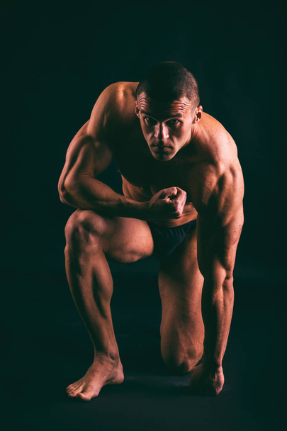 muscular male body on a dark background. - Zdjęcie, obraz