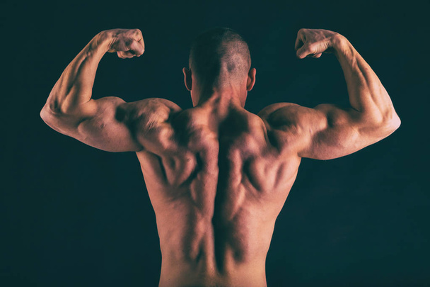 Θέτοντας σε διαφορετικές πόζες, επιδεικνύοντας τους μυς του bodybuilder - Φωτογραφία, εικόνα