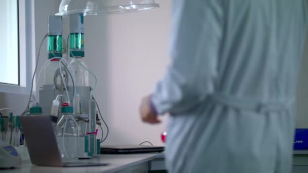 Wetenschappers in een lab. Wetenschapper brengt glas kolf met chemische vloeistof in lab - Video