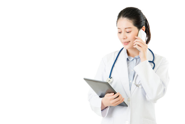 happy asian doctor holding digital tablet using smartphone - Zdjęcie, obraz