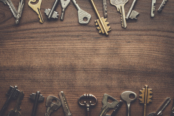 many different keys on wooden table - Fotografie, Obrázek