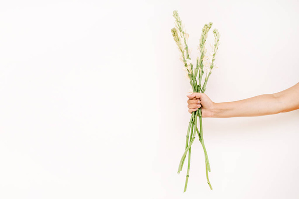 Mano de niña sosteniendo ramo de flores blancas
 - Foto, Imagen