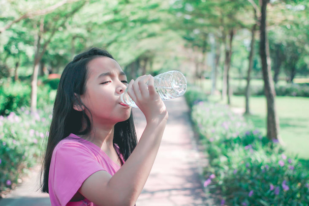 Kind drinkwater in park. - Foto, afbeelding