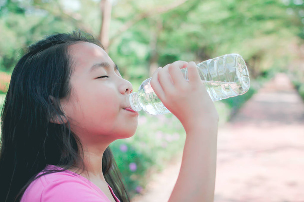 Child drinking water in park. - Photo, Image