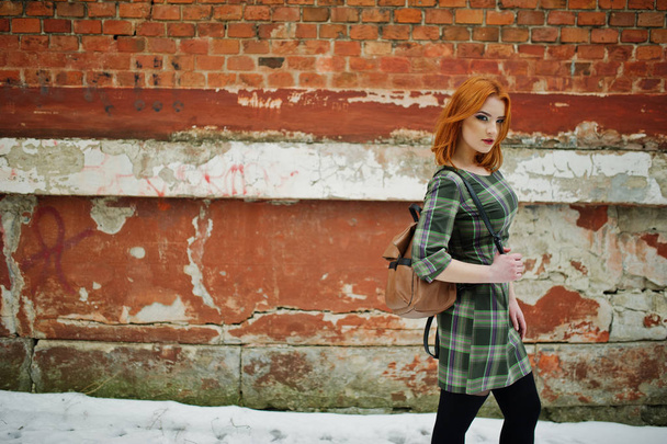 An outdoor portrait of a young pretty girl with red hair wearing - 写真・画像