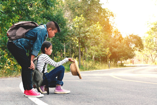 glückliche asiatische Kinder Rucksack in der Straße und Wald Hintergrund - Foto, Bild