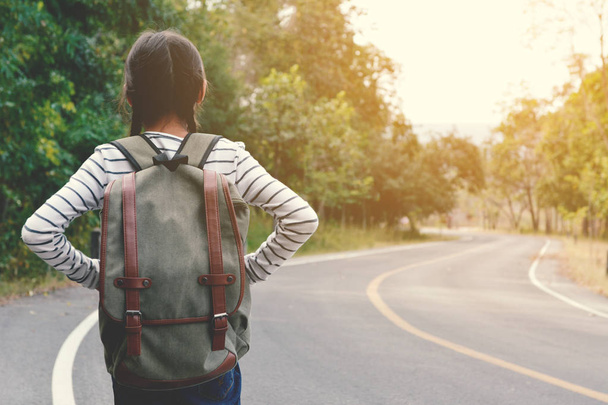 Happy Asian girl backpack in the road and forest background - 写真・画像