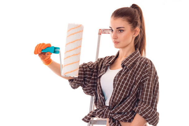 charming brunette lady builder makes renovation isolated on white background - Φωτογραφία, εικόνα