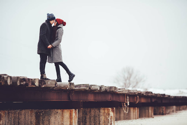 Молодой парень и девушка в зимней одежде, обнять и наслаждаться пейзажем зимы
. - Фото, изображение