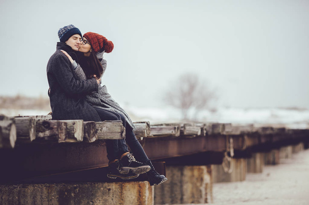 Νέος τύπος και το κορίτσι σε φθορά χειμώνα, να αγκαλιάσει και να απολαύσετε το τοπίο του χειμώνα. - Φωτογραφία, εικόνα