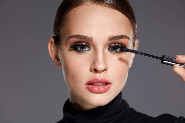 Beauty. Beautiful Woman Applying Black Mascara On Eyelashes - Foto, imagen