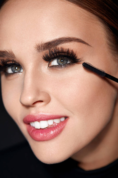 Cosmetics. Beautiful Woman With Perfect Makeup Applying Mascara - Фото, зображення
