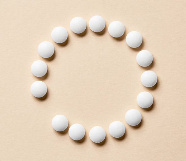 white pills on beige background - Fotó, kép
